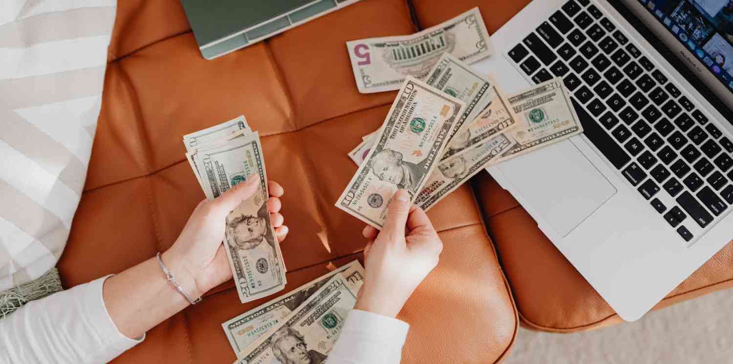 money being counted in front of a computer